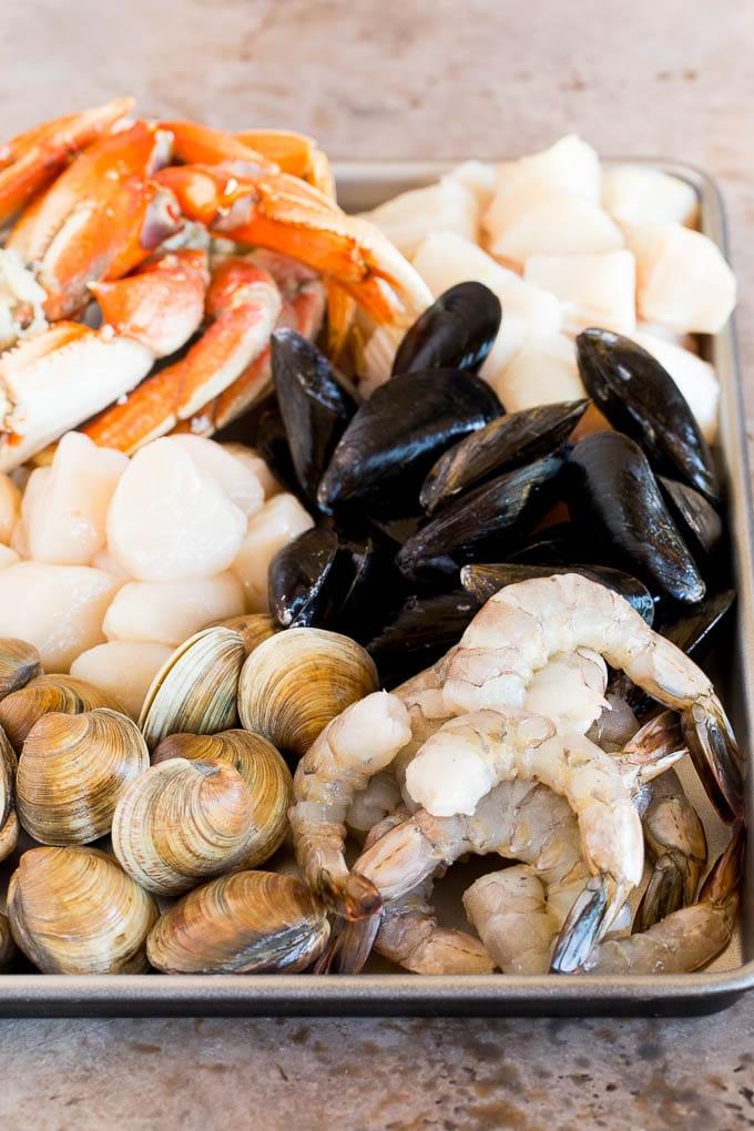 Ein Backblech mit einer vielfältigen Auswahl an frischen Meeresfrüchten und Schalentieren, sorgfältig vorbereitet und bereit für die Zubereitung des köstlichen Cioppino.