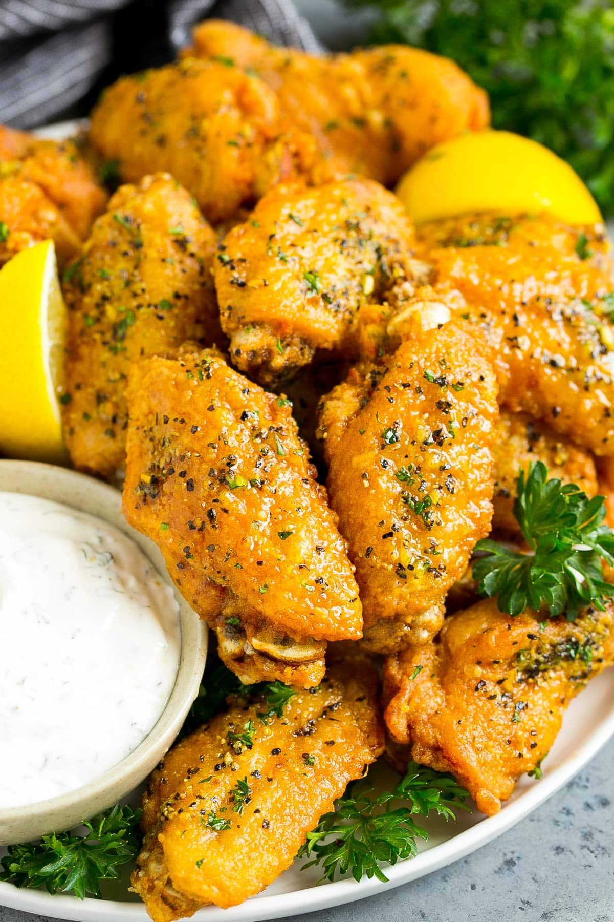 Zitronenpfeffer-Flügel 6 Eine Platte mit Zitronen-Pfeffer-Hähnchenflügeln, serviert mit Ranch-Dressing.