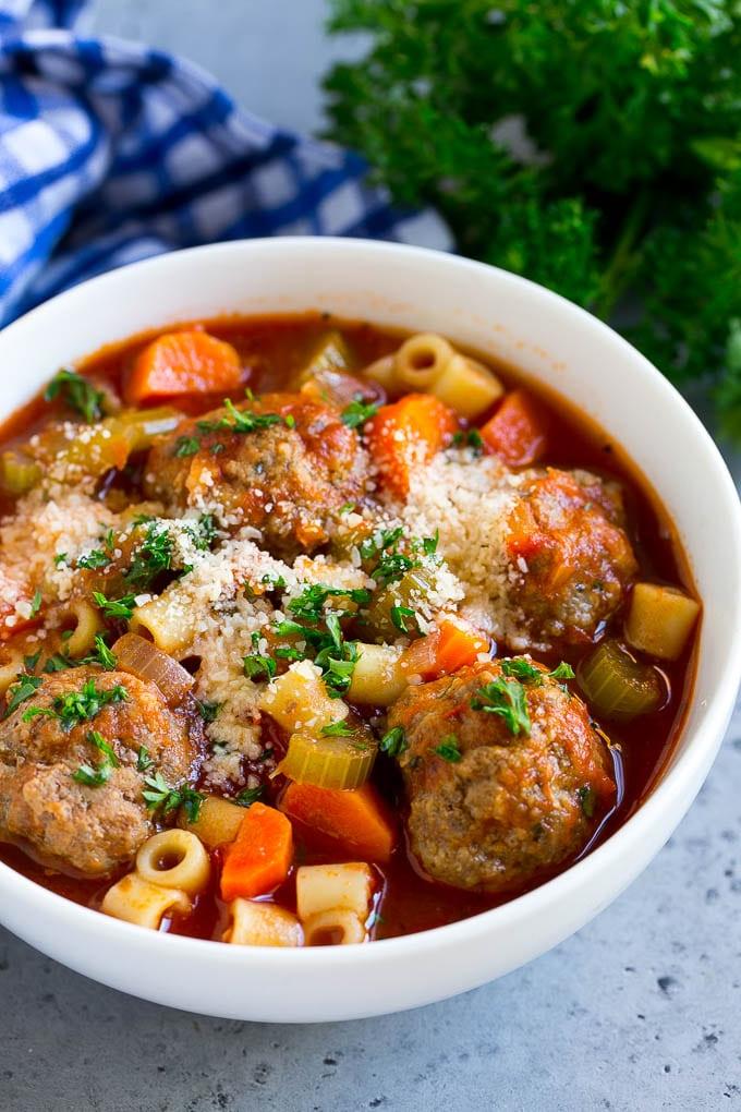 Italienische Frikadellensuppe Rezept | Fleischbällchensuppe | Rinderhackbällchen #fleischbällchen #rind #suppe #italienisch #abendessen #ahurt #wohlfühlessen Eine Schüssel Fleischbällchensuppe, garniert mit gehackter Petersilie und geriebenem Käse.