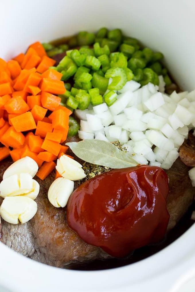 Rinderbrust, Gemüse, Kräuter und Gewürze in einem Slow Cooker.