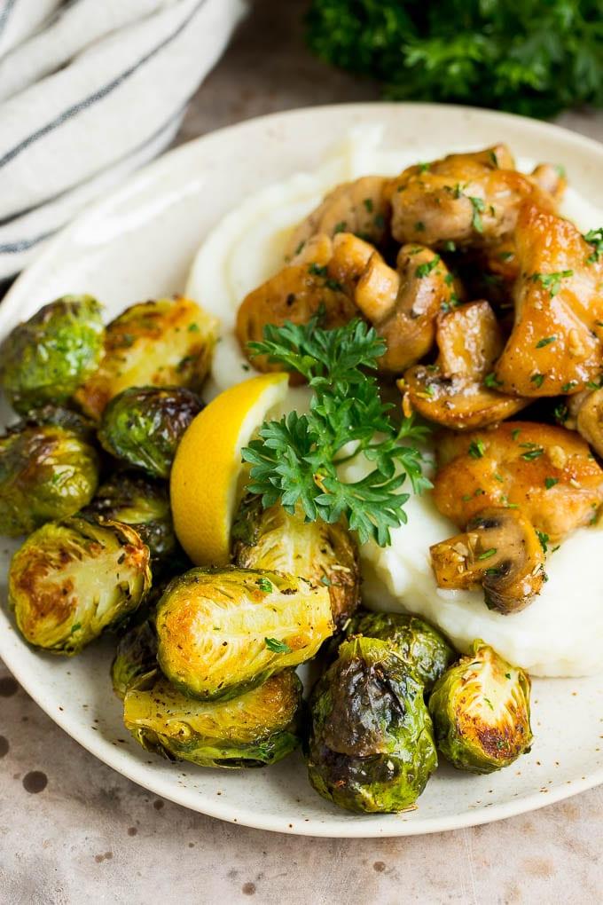 Dieser knusprige Rosenkohl ist mit Olivenöl, Knoblauch und Gewürzen überzogen und wird bei hoher Hitze geröstet, bis er zart und goldbraun ist. Knuspriger Rosenkohl serviert mit cremigem Kartoffelpüree und saftigem Knoblauchhähnchen – eine perfekte, ausgewogene Mahlzeit.