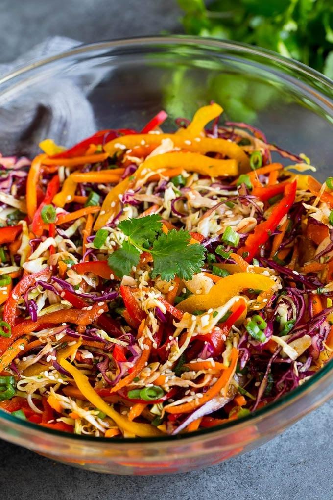 Asiatischer Krautsalat Rezept - Fertig zum Servieren Eine Schüssel asiatischer Krautsalat, garniert mit Sesamkörnern und Kräutern.
