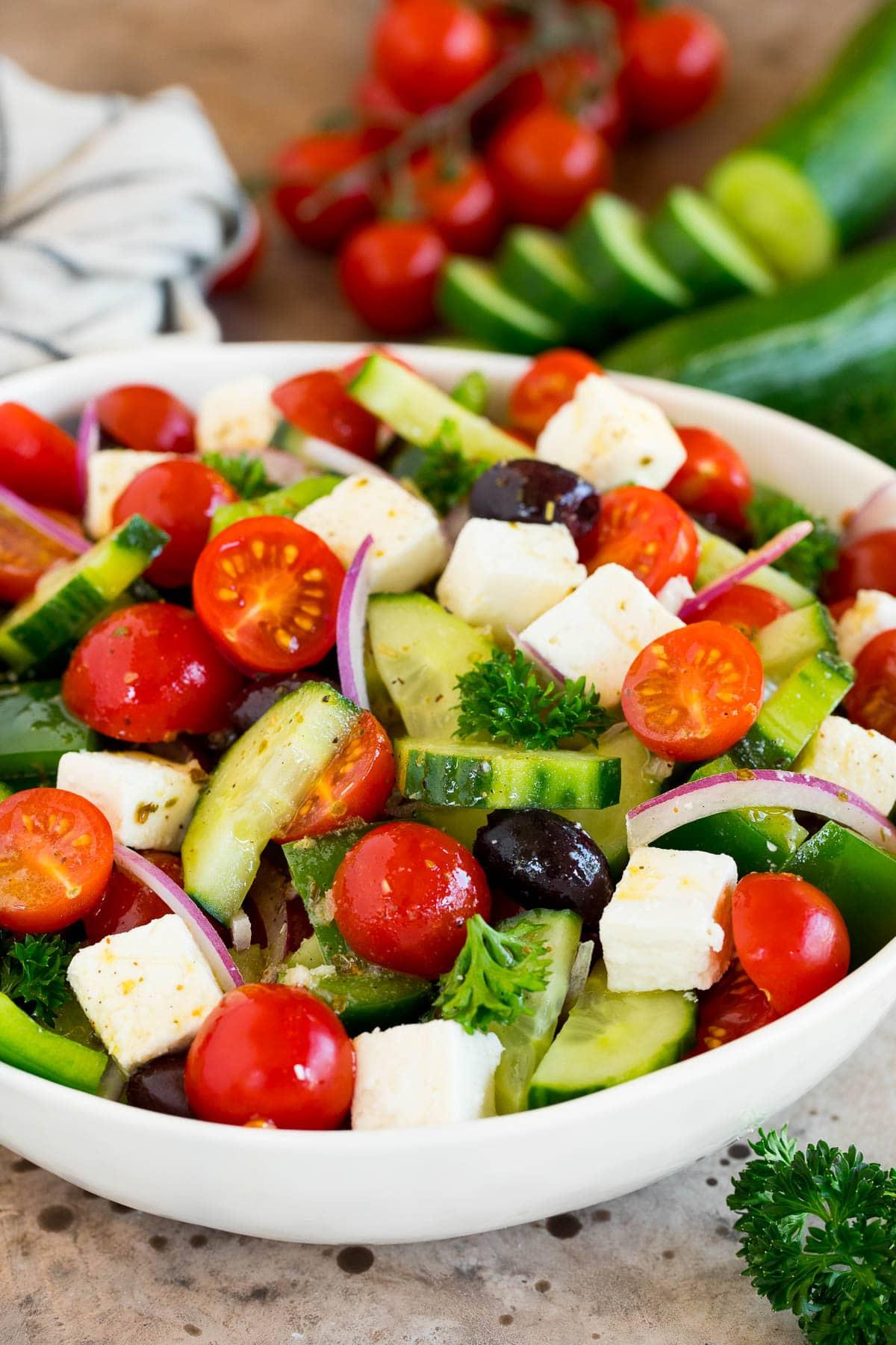 Griechisches Salatdressing 6 Ein gehackter griechischer Salat mit Gurken, Tomaten, Kalamata-Oliven und Feta-Käse, fertig zum Servieren.