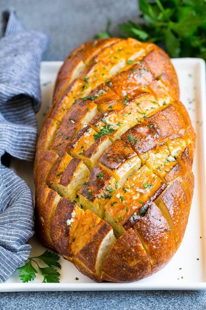 Zupfbrot | Knoblauchbrot | Käsebrot #brot #knoblauch #käse #beilage #vorspeise #ahurt Gebackenes Knoblauch-Zupfbrot mit Petersilie garniert.