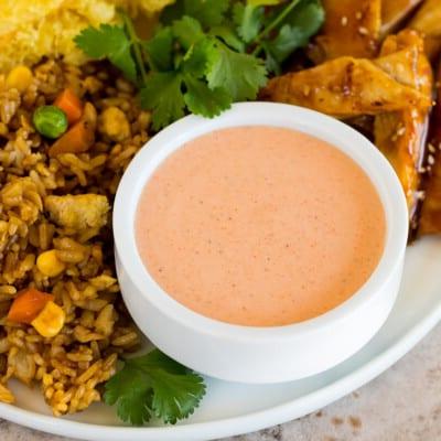 Yum Yum Sauce Rezept 7 Eine Schale Yum Yum Sauce auf einem Teller mit gebratenem Reis und Hähnchen.