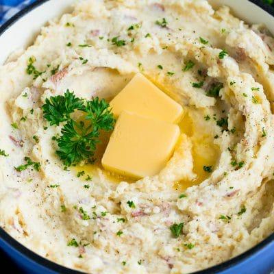 Rotes Kartoffelpüree 2 Ein Topf mit Kartoffelpüree aus roten Kartoffeln, garniert mit Butter und Petersilie.