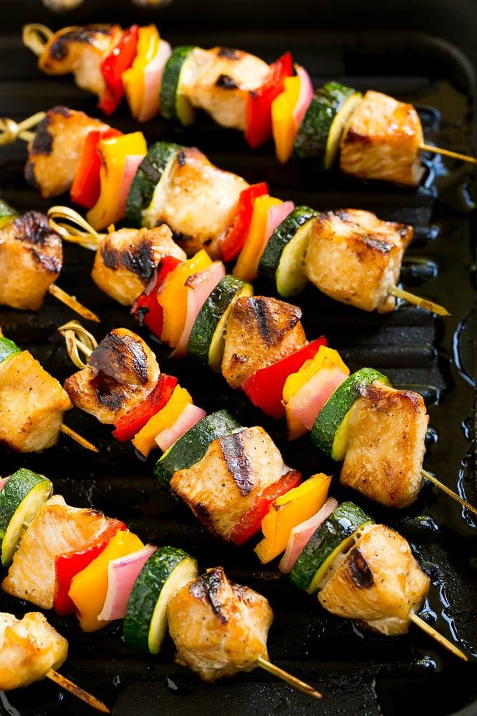 Gegrillte Hähnchenspieße auf einer Grillpfanne.