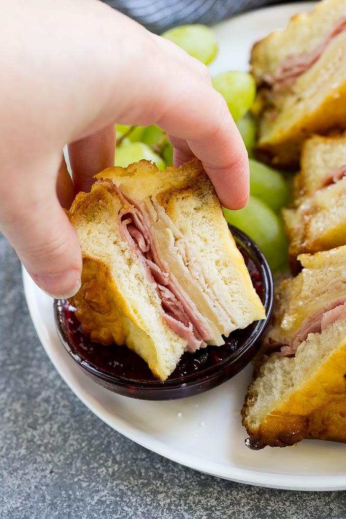 Ein Monte Cristo Sandwich, liebevoll in Himbeermarmelade getaucht, unterstreicht die süß-herzhafte Geschmackskombination.