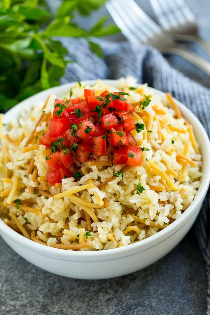 Eine Schüssel hausgemachtes Rice-A-Roni, garniert mit gehackten Tomaten und Kräutern.