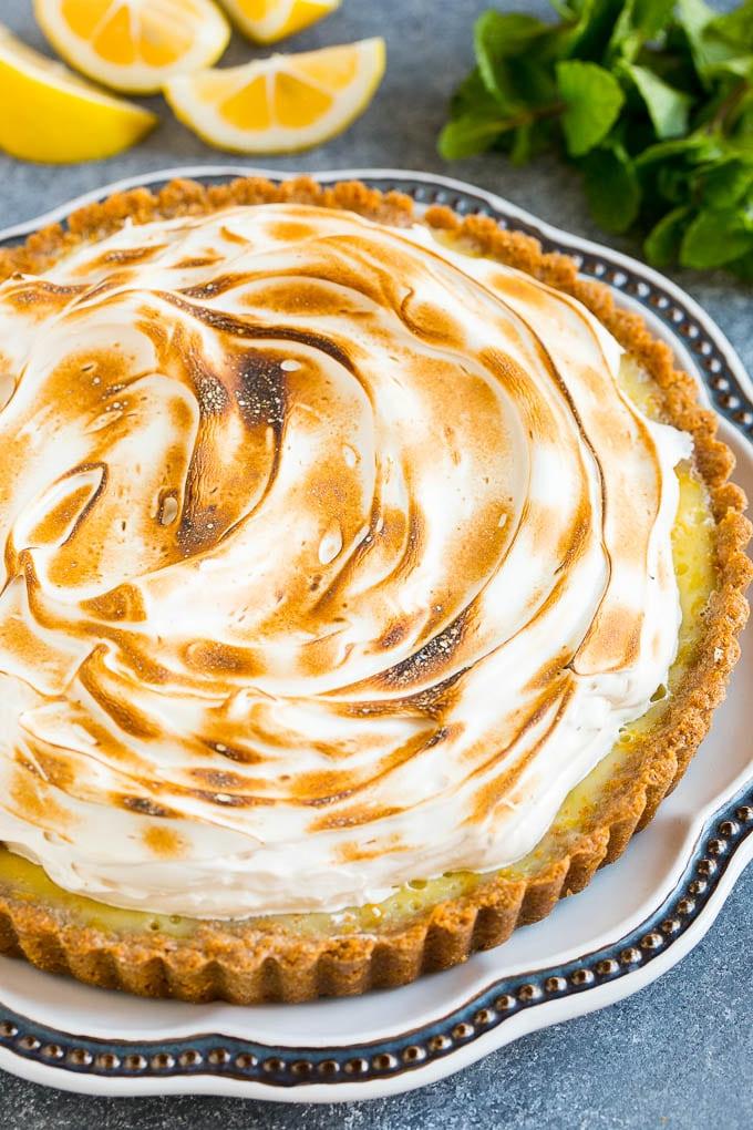 Eine Zitronen-Baiser-Tarte, gekrönt mit getoastetem Baiser aus braunem Zucker.