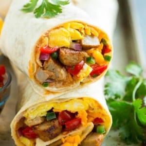 Ein Querschnitt eines Frühstücks-Burritos, gefüllt mit Eiern, Wurst, Bohnen und Käse.