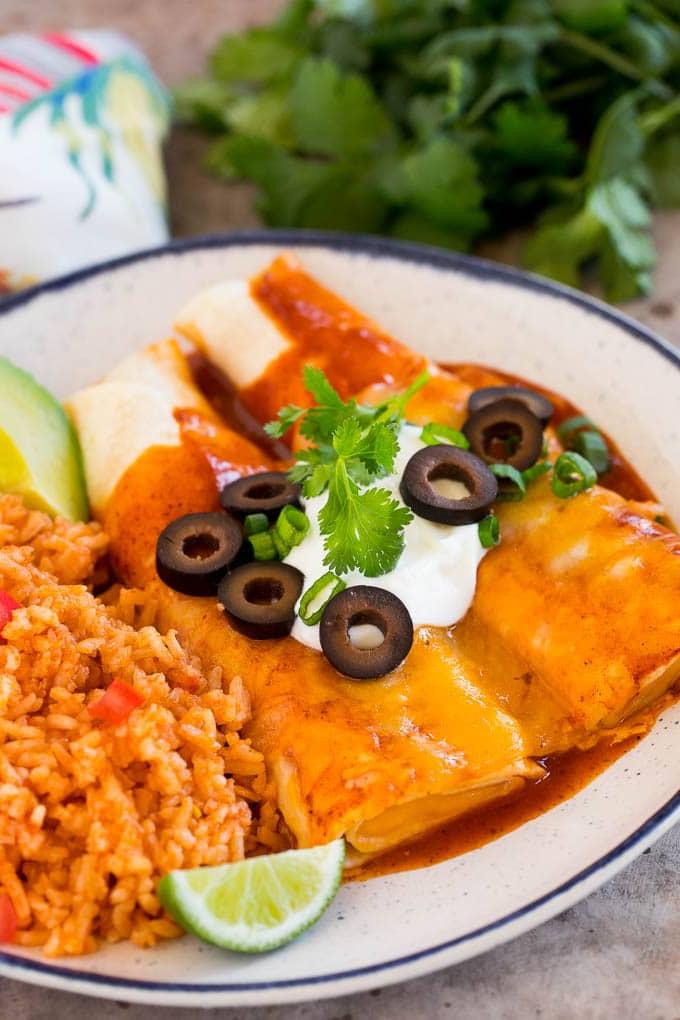 Ein Teller Käse-Enchiladas, serviert mit einer Beilage von mexikanischem Reis, bereit zum Genießen.