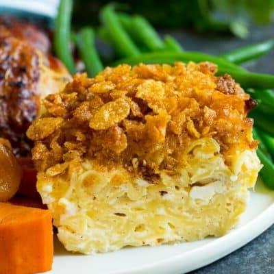 Ein Portion Nudel Kugel auf einem Teller, serviert mit Hühnchen und Gemüse.