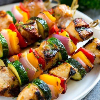 Gegrillte Hähnchenspieße 2 Ein Teller mit gegrillten Hähnchenspießen, zubereitet mit mariniertem Hähnchen und farbenfrohem Gemüse.