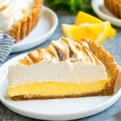 Zitronenbaisertarte 2 Ein Stück Zitronen-Baiser-Tarte mit cremiger Zitronenfüllung und braunem Zucker Baiser-Topping.