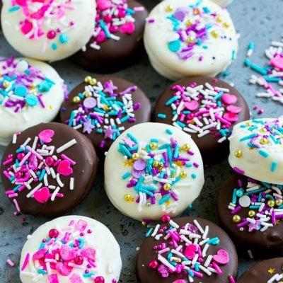 Schokoladenüberzogene Oreos 2 Rosa und lila Streuseln verzierte Schoko-Oreos.