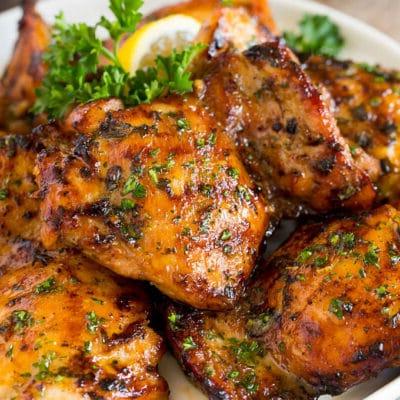 Hähnchenschenkelmarinade 2 Hähnchenschenkel mit Marinade auf dem Grillrost, fertig zum Servieren.