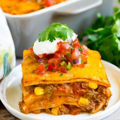 Taco-Lasagne 2 Eine Scheibe Taco-Lasagne garniert mit Salsa, Sauerrahm und Koriander.