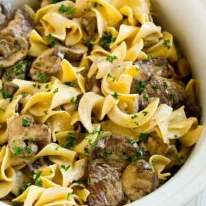 14 Slow Cooker Nudelrezepte 9 Slow Cooker Rinder-Stroganoff mit Rinderstücken, Pilzen und Eiernudeln, garniert mit Petersilie.