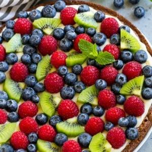 Brownie-Pizza belegt mit Frischkäse-Frosting und frischen Früchten.