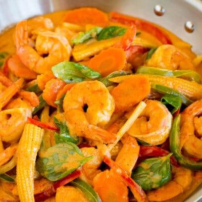 Garnelen-Curry 2 Eine Pfanne mit Garnelen-Curry, verschiedenen Gemüsesorten und frischem Basilikum.