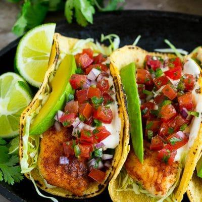 Fisch-Tacos mit Avocado 2 Mais-Tortillas in Fisch-Tacos gewickelt mit Avocadoscheiben und Pico de Gallo.