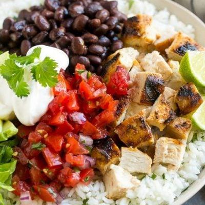 Burrito Bowls mit Hähnchen 2 Diese Burrito Bowls sind vollgepackt mit mariniertem Grillhähnchen, Koriander-Limetten-Reis, schwarzen Bohnen und einer Vielzahl an köstlichen Toppings. Dieses Rezept wird garantiert zu einem festen Bestandteil Ihres Essensplans!