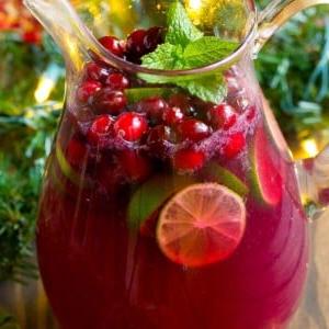 Ein Krug mit Weihnachtspunsch, garniert mit Cranberries und Minze.