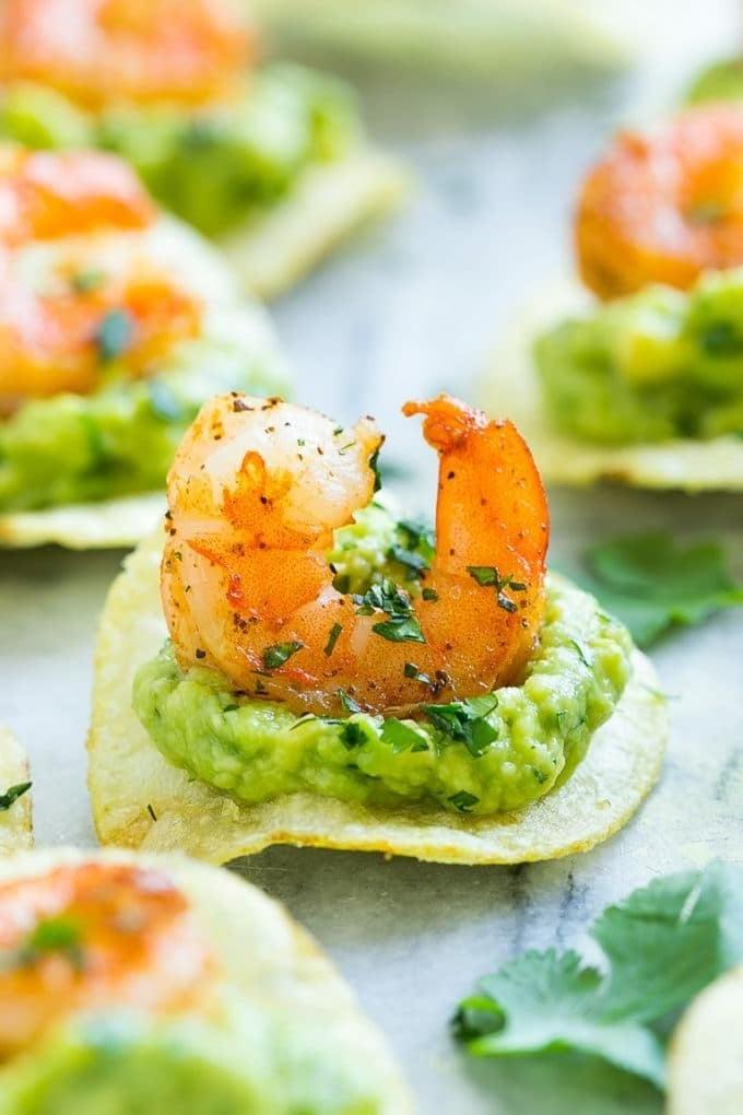Mexikanische Garnelen-Häppchen mit Guacamole, gewürzten Garnelen und Kartoffelchips.