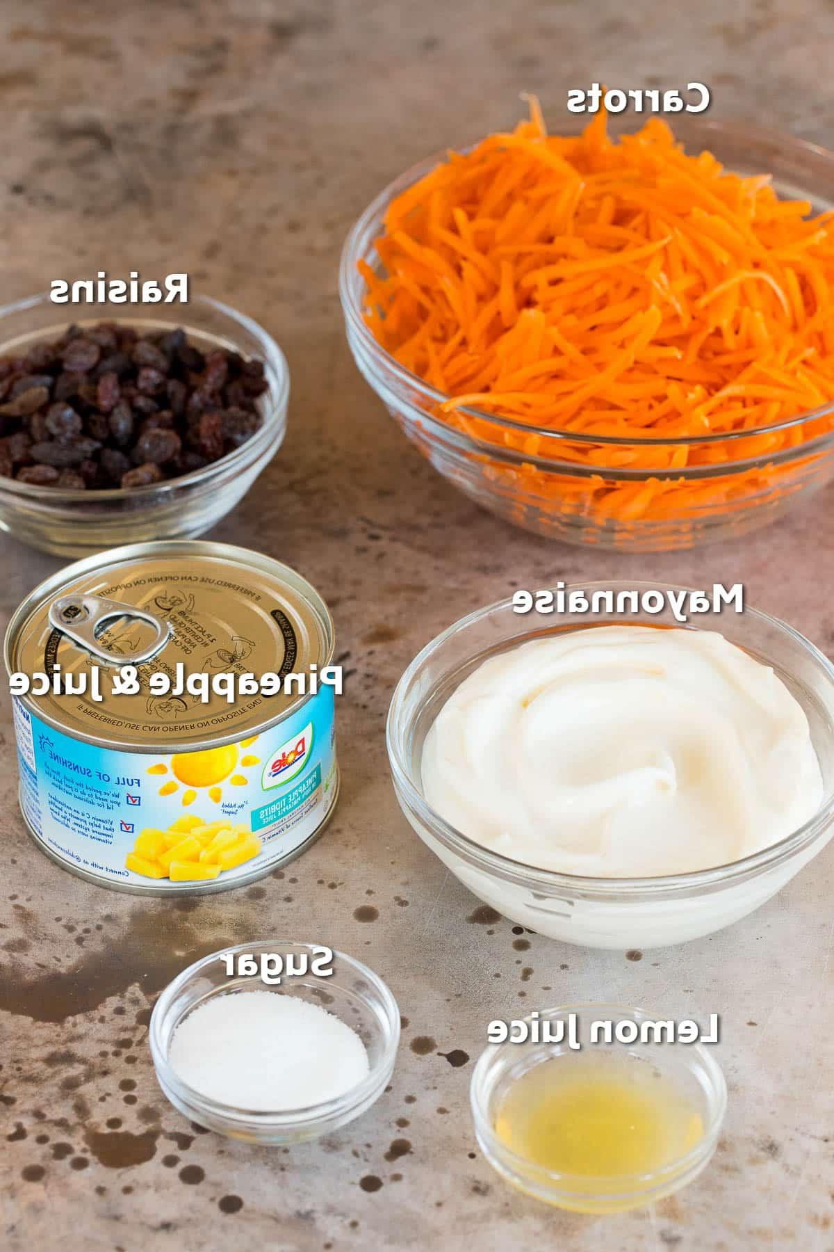 Karottensalat 3 Schüsseln mit Zutaten wie Karotten, Rosinen, Mayonnaise und Gewürzen.