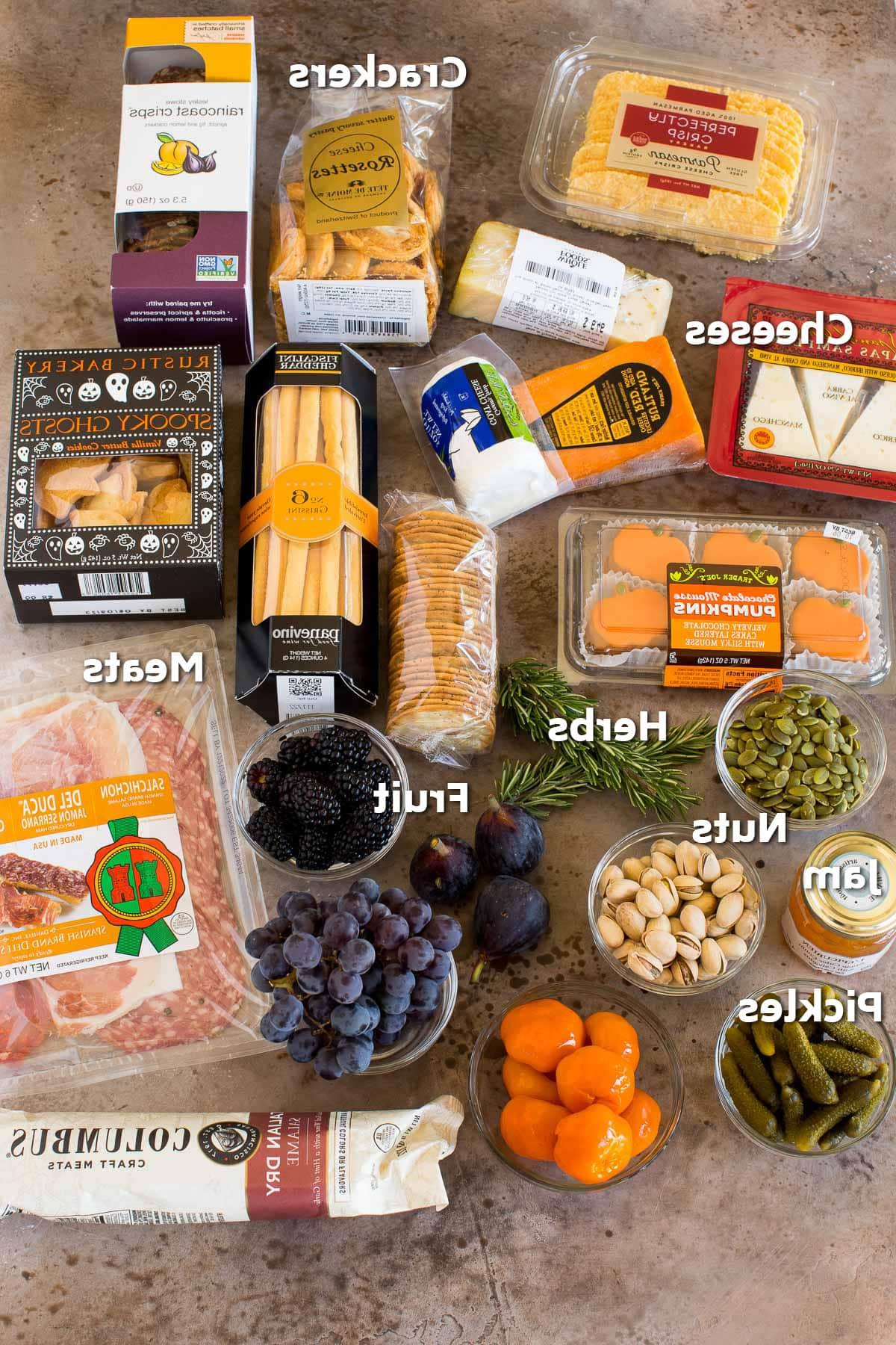 Halloween Platte 3 Zutaten, darunter Packungen mit Crackern, Wurst und Käse.