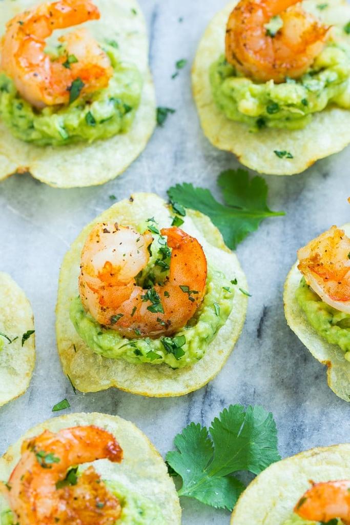 Kartoffelchips belegt mit Guacamole und einer gebratenen Garnele.
