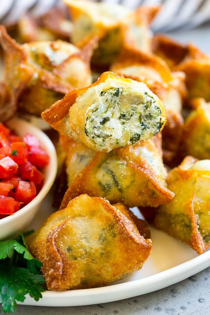 Spinat-Artischocken-Wontons mit hausgemachtem Spinat-Artischocken-Dip, gefüllt in Wonton-Blätter und frittiert.
