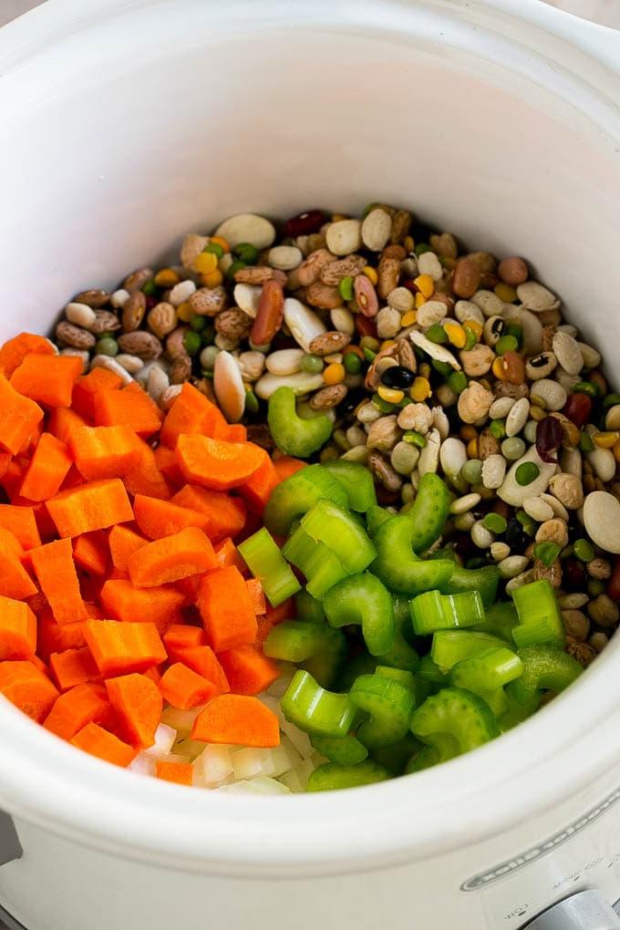 Schinken-Bohnen-Suppen-Rezept | Slow Cooker Schinken-Bohnen-Suppe | Crockpot Schinken-Bohnen-Suppe | Rezept für Schinkenreste #schinken #bohnen #suppe #slowcooker #crockpot #abendessen #abendessenimzoo Getrocknete Bohnen, Karotten, Zwiebeln und Sellerie im Slow Cooker.