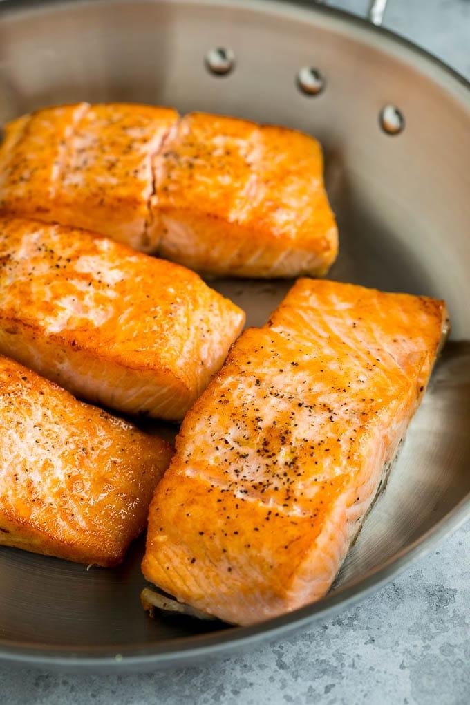 Gebratener Lachs in der Pfanne | Schnelles Fischgericht | Einfaches Abendessen Sautierte Lachsfilets in einer Metallpfanne, kurz vor dem Servieren.