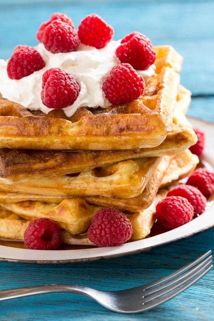 Hefewaffeln mit Ahornsirup, Schlagsahne und Beeren belegt.