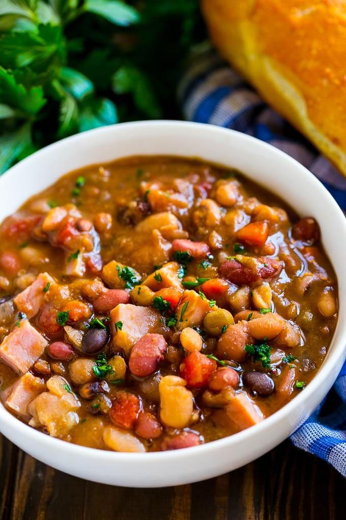 Schinkenknochensuppe Slow Cooker | Schinken-Bohnen-Suppe | Schinkenknochen-Bohnen-Suppe | Schinkensuppe | Rezept für Schinkenreste #schinken #schinkensuppe #schinkenreste #suppe #slowcooker #crockpot #ahurt Schinkenknochensuppe im Slow Cooker, in einer Schüssel mit Petersilie garniert.