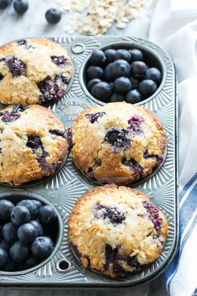 Draufsicht auf Muffins in einer Form mit frischen Blaubeeren.