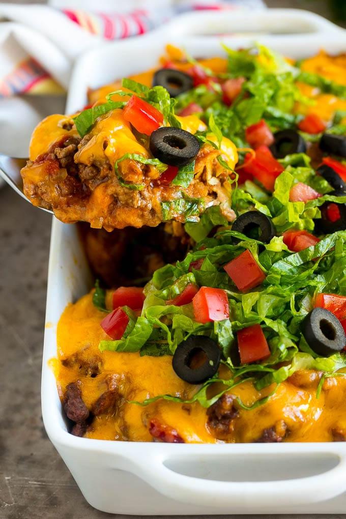 Ein Löffel serviert eine Portion Rindfleisch-Taco-Auflauf.