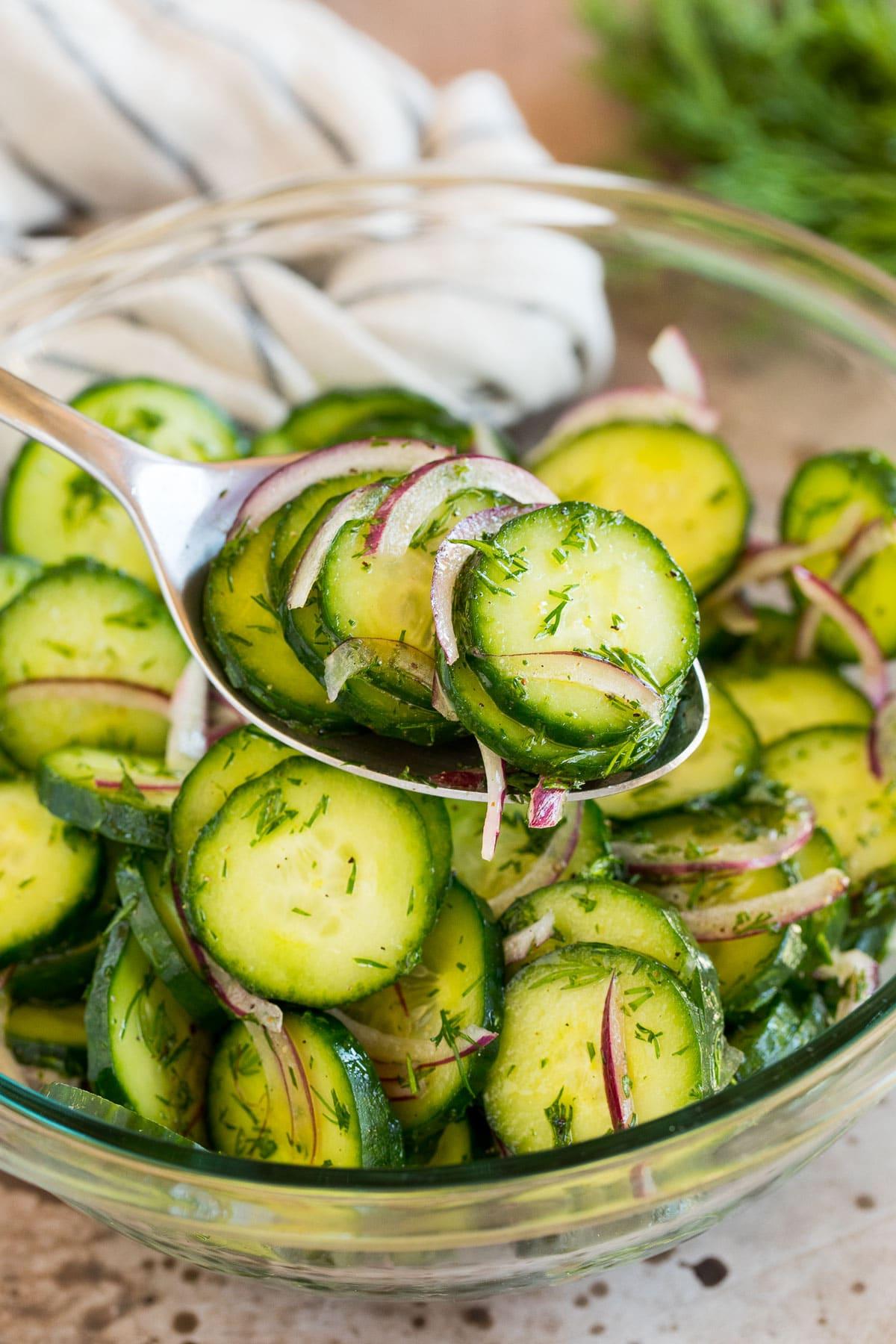 Ein Löffel serviert eine Portion Gurken-Dill-Salat.