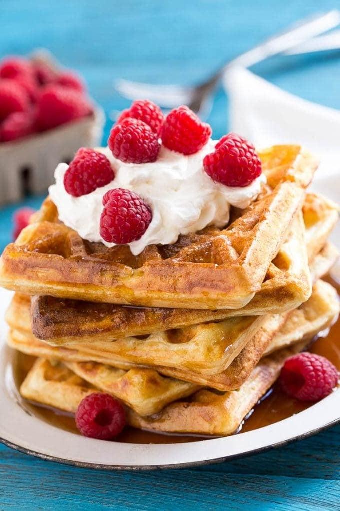 Übernacht-Waffeln mit Schlagsahne und Himbeeren garniert.