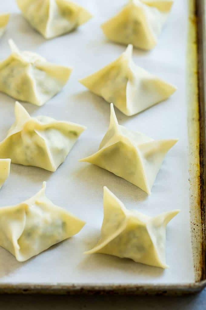 Gefaltete Wontons auf einem Backblech.