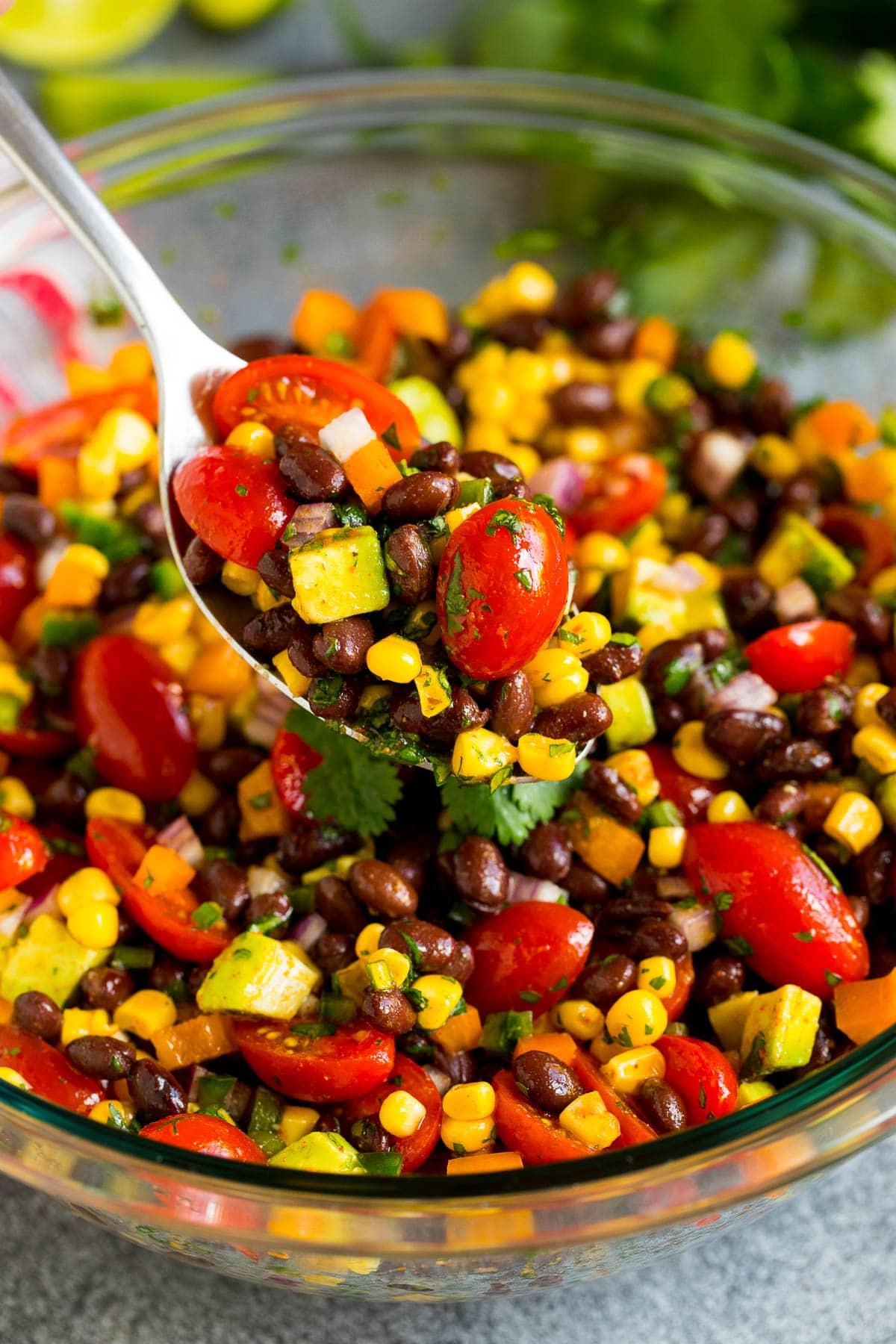 Ein Servierlöffel voller schwarzem Bohnensalat.