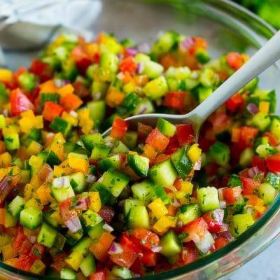 Rezept für Israelischen Salat 2 Eine Schüssel Israelischer Salat mit einem Servierlöffel darin.