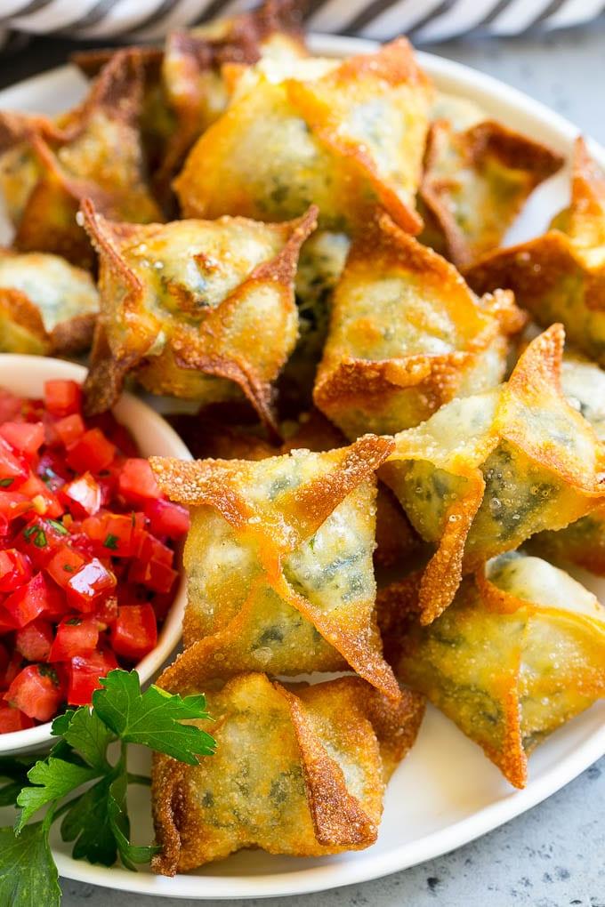 Spinat-Artischocken-Wontons auf einem Servierteller.