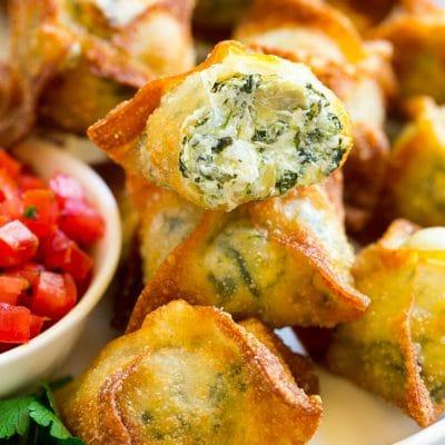 Spinat-Artischocken-Wantan 2 Spinat-Artischocken-Wontons mit hausgemachtem Spinat-Artischocken-Dip, gefüllt in Wonton-Blätter und frittiert.