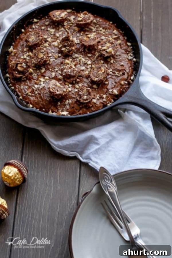 Ultimate Ferrero Rocher Skillet Brookie 4 A Ferrero Rocher Deep Dish Skillet Brownie Cookie baking in a cast iron pan, showing its rich, dark surface.