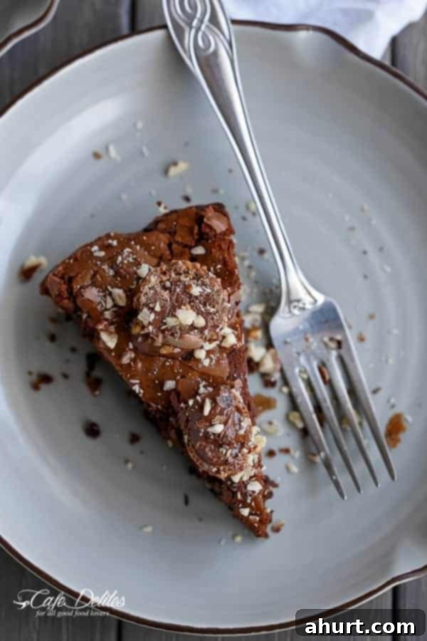 Ultimate Ferrero Rocher Skillet Brookie 10 A piece of Ferrero Rocher Deep Dish Skillet Brownie Cookie on a plate with a fork, ready to be enjoyed.