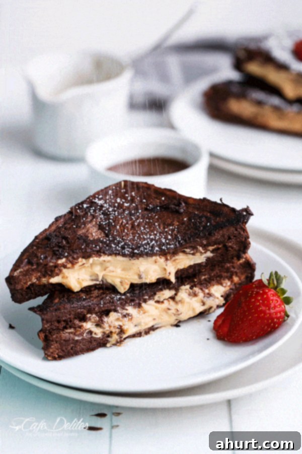 Powdered sugar drizzled over Peanut Butter Cheesecake Stuffed Chocolate Brownie French Toasts 