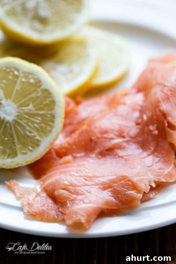 Raw salmon pieces arranged with half a cut lemon, highlighting the freshness of the ingredients.